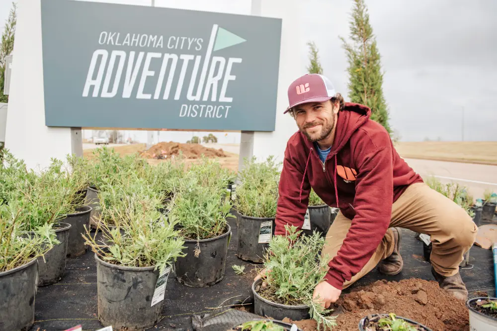 Willis Commercial Landscaping tech planting bushes at OKC Adventure District Willis Commercial Landscaping tech planting bushes at OKC Adventure District