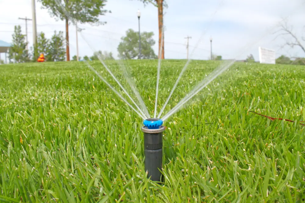 Sprinkler head spraying water on green grass Sprinkler head spraying water on green grass