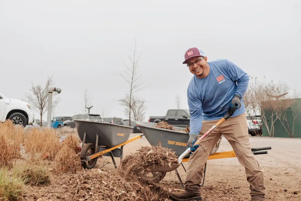 Willis Commercial Landscaping tech smiling while mulching Willis Commercial Landscaping tech smiling while mulching